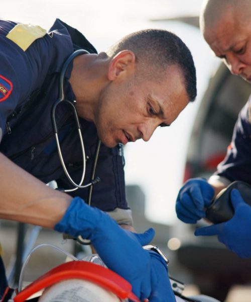Paramedic, emergency and men with accident in road for first aid, resuscitation and rescue service.